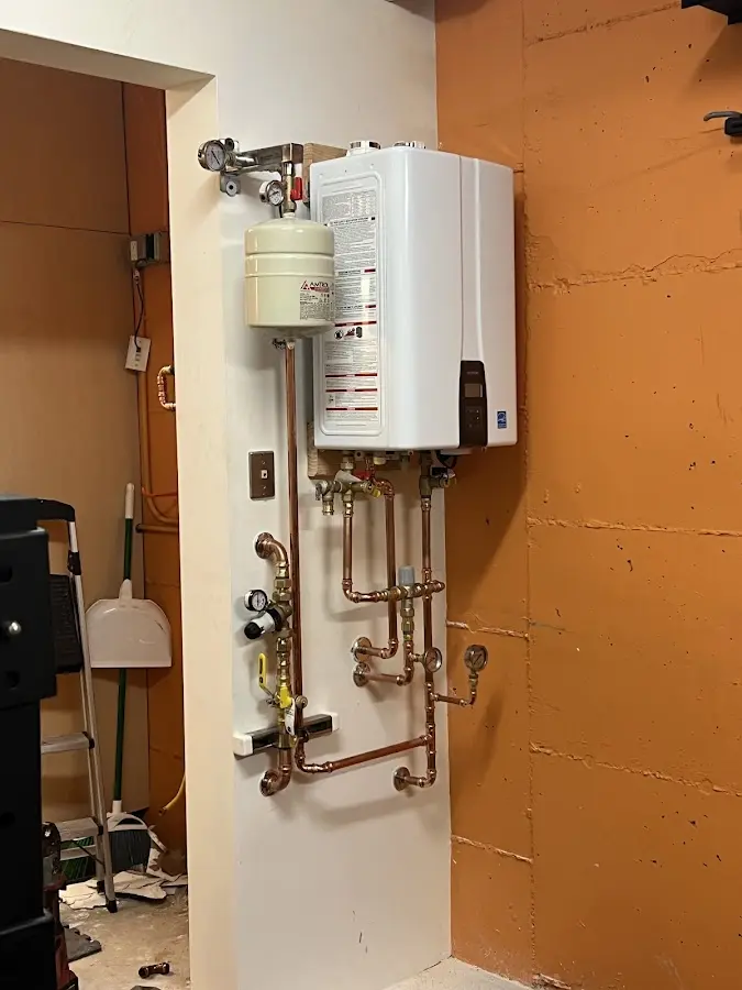 Plumbing technician inspecting water heater connections in Linganore